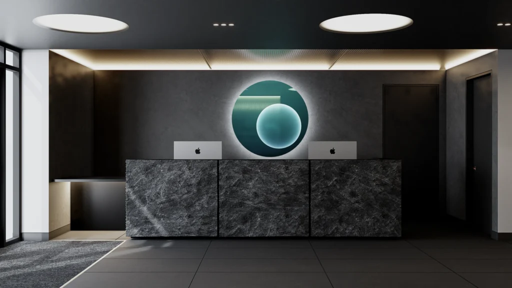 Gym reception area with dark grey walls, flooring, and tiling, featuring a circular mirror as a focal point.